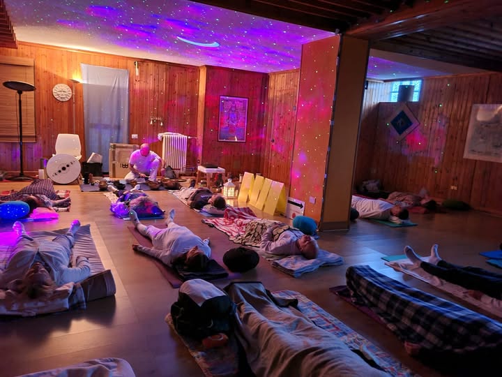 Bagno sonoro di gruppo con luci soffuse e partecipanti distesi
